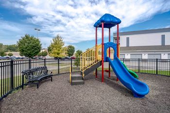 A playground with a blue slide and a yellow and red structure.